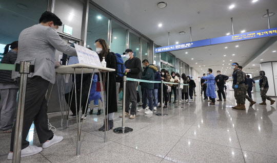 중국발 입국자의 코로나19 음성확인서 제출 의무화 4일차인 지난 8일 검사 양성률이 3.9％로 떨어졌다. 사진은 9일 인천국제공항 제2여객터미널 코로나19 검사센터에서 검사를 기다리는 중국발 입국자들.  연합뉴스